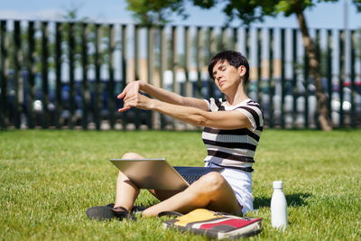 Side view of young woman exercising in park