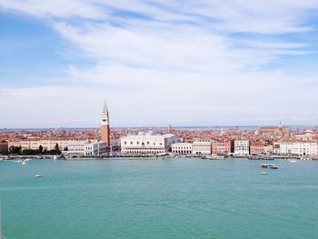 Boats in sea with buildings in background