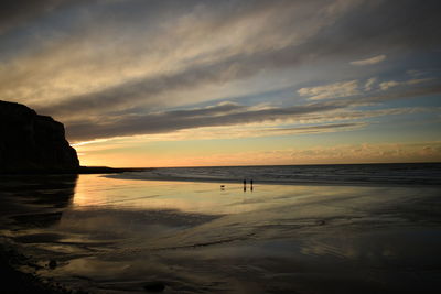 Scenic view of beach against sky during sunset