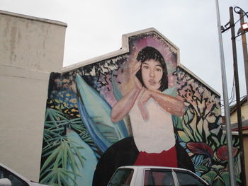 Portrait of woman standing against built structure