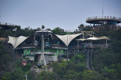 Built structure by trees against clear sky