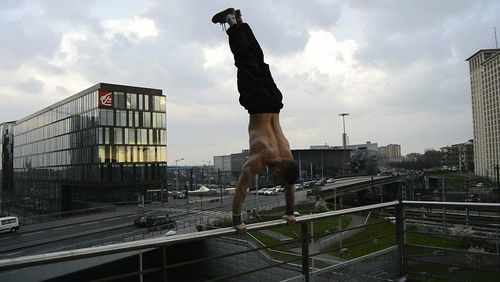 Man with cityscape against cloudy sky