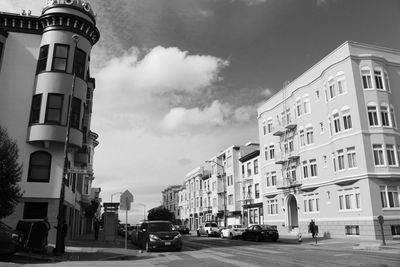 Cars on city street against sky