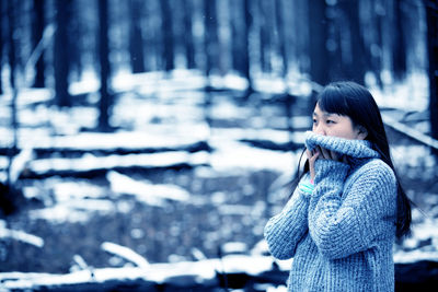 Woman on snow covered tree