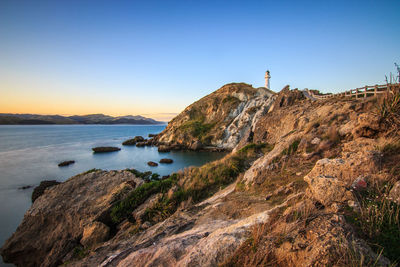 View of rocky coastline against clear blue sky