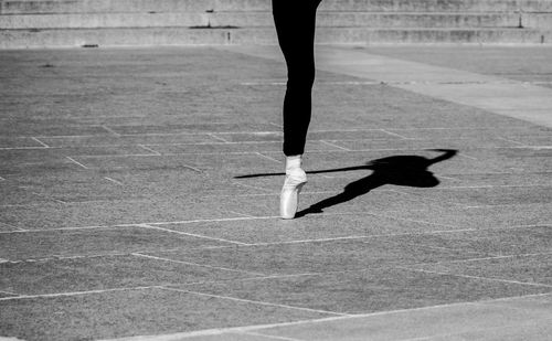 Low section of woman ballet dancer on footpath