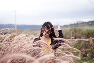 Portrait of woman on field against sky