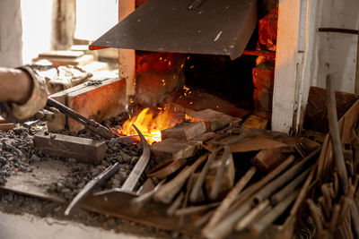 The blacksmith in production process of metal products, handmade in the forge. craftsman heats metal