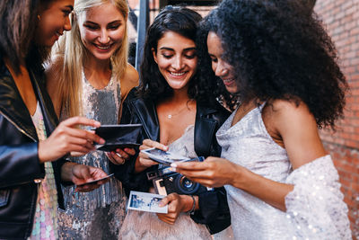 Young woman holding hands while using smart phone