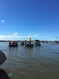 People on boat in river against sky