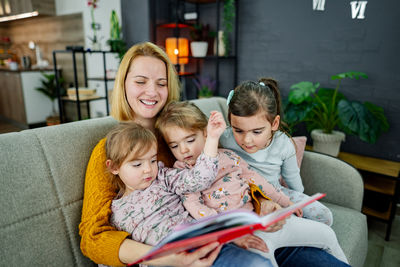 Portrait of happy family sitting on sofa at home