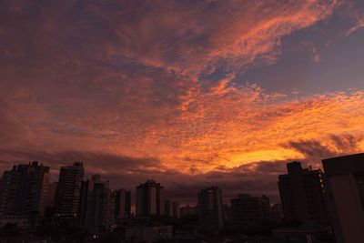 Buildings against dramatic sky during sunset