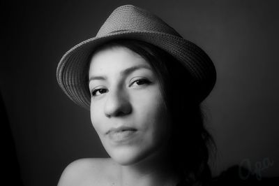 Portrait of beautiful young woman against black background