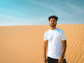 Portrait of young man standing against sky during sunset