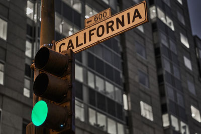 Low angle view of road sign against building in city