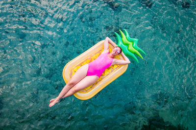 High angle view of young man floating in swimming pool