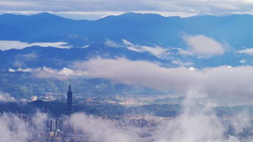 Aerial view of city against cloudy sky