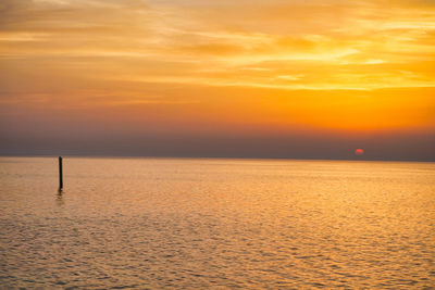 Scenic view of sea against orange sky