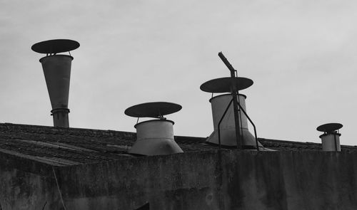 Low angle view of bird perching on street light against sky