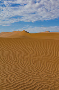 Sand dunes in desert against sky