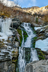 Scenic view of waterfall against sky