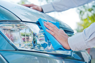 Midsection of man holding umbrella in car