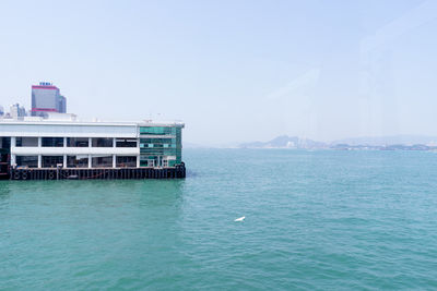 Scenic view of sea against buildings against clear sky