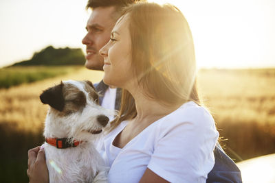 Couple with dog against clear sky