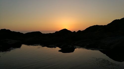 Scenic view of silhouette mountains against clear sky during sunset