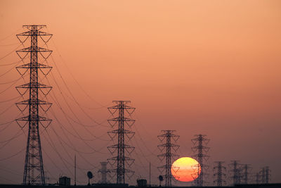 Sunset with silhouettes of power transmission towers.