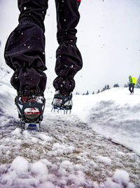 Low section of man skiing on snow covered field