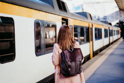 Rear view of woman on train at railroad station platform