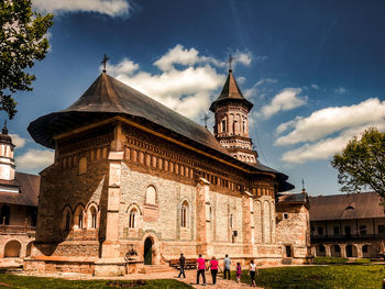 Group of people in front of historic building against sky