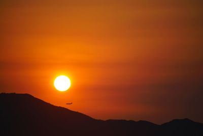 Scenic view of silhouette mountains against romantic sky at sunset