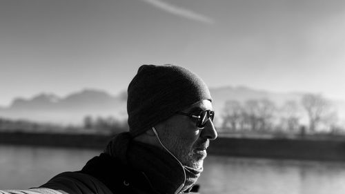 Close-up of man wearing sunglasses and knit hat standing outdoors during winter