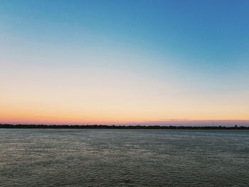 Scenic view of sea against clear sky during sunset