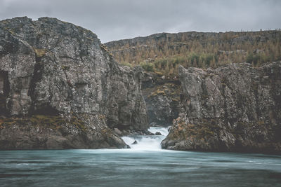 Scenic view of waterfall against sky