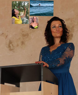 Portrait of woman standing against wall