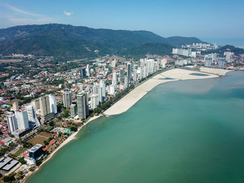 High angle view of city by sea against sky