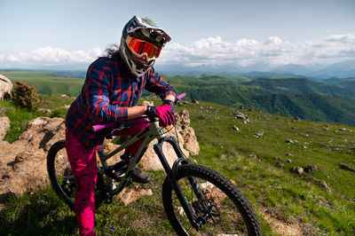 Rear view of man riding bicycle on mountain