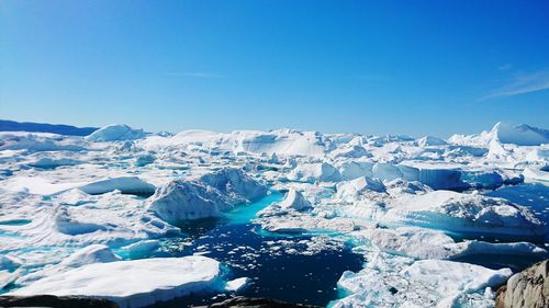 Scenic view of snow covered landscape against clear blue sky