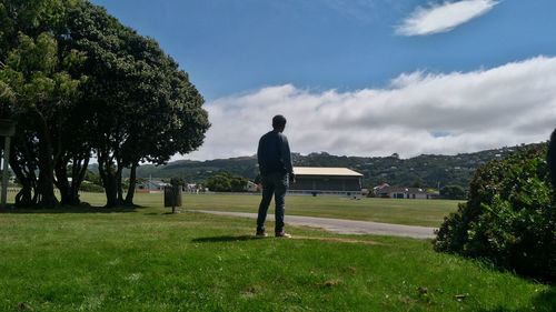 Man standing on golf course against sky