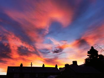 Low angle view of silhouette buildings against dramatic sky