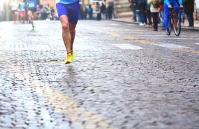 Low section of people running on road in city