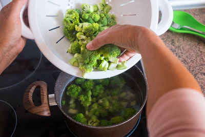 Cropped hands of person preparing broccoli