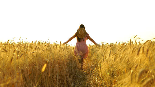 Rear view of woman standing on field