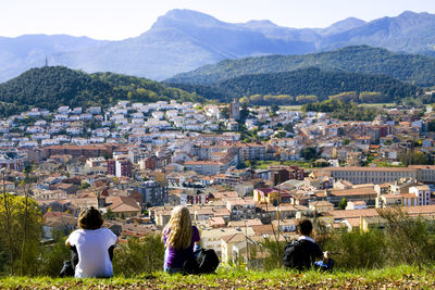 People sitting against cityscape