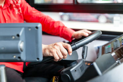 Midsection of man using mobile phone in bus