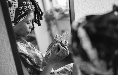 Woman holding equipment reflecting on mirror at home