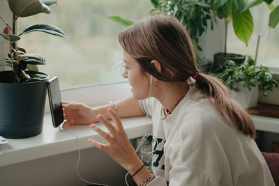 A young pretty woman in headphones communicates via video chat with mobile phone. high quality photo